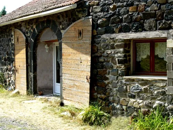 Gîte 2 — porte cintrée en bois et façade de pierre